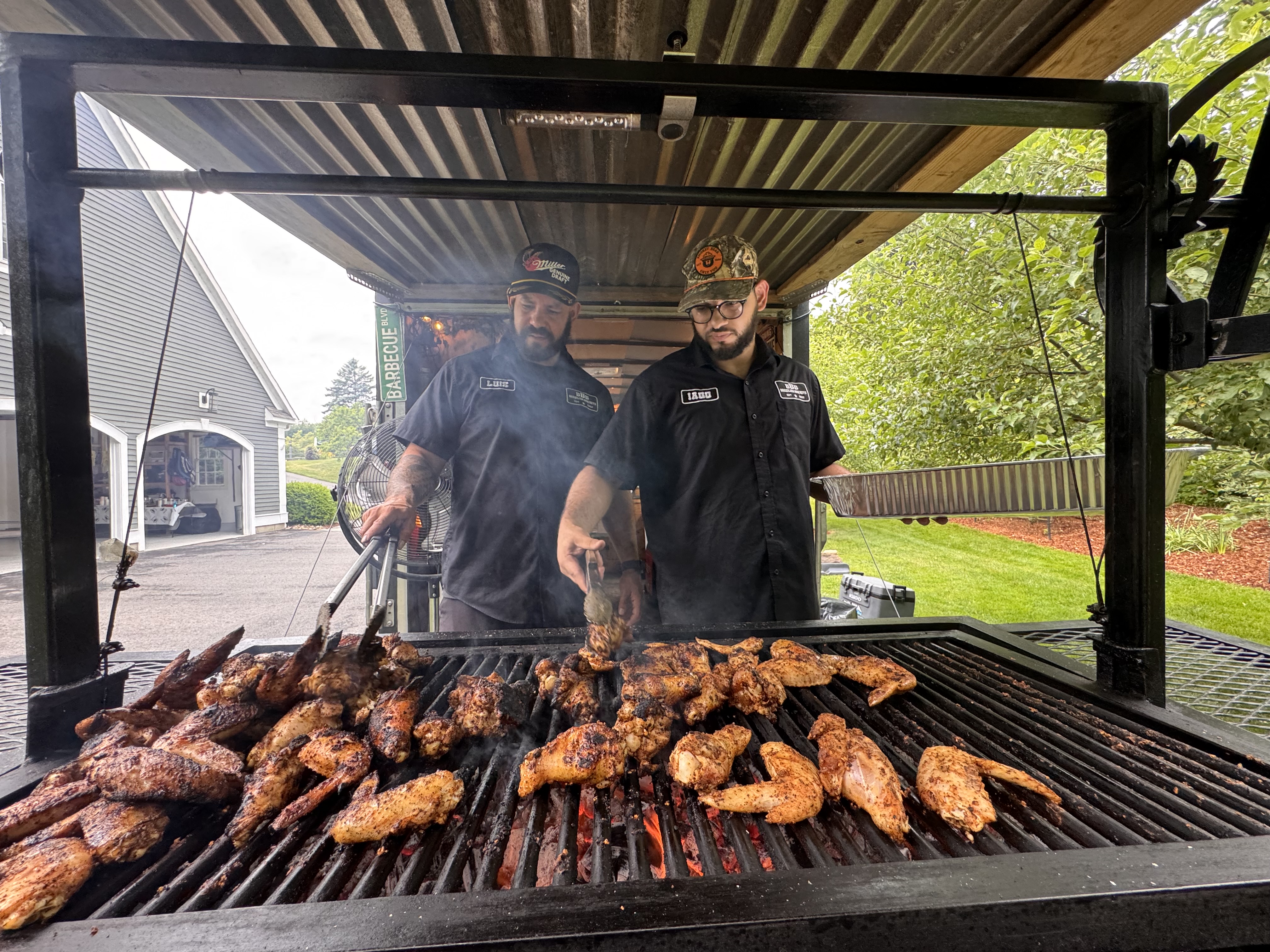 Brothers Luis and Iago grilling up chicken wings together - teamwork in action